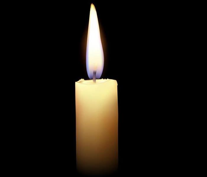 Candle with flame and black background